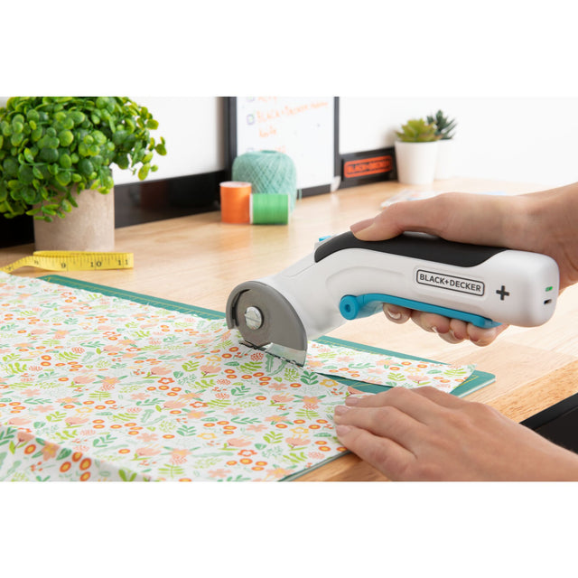 Person using rotary cutter on fabric