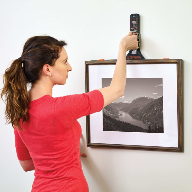 woman using picture hanging tool