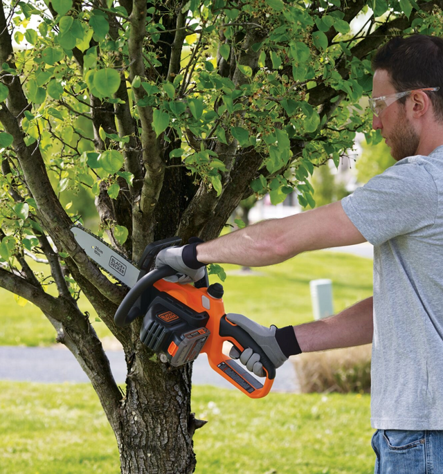 Man using BLACK+DECKER chainsaw