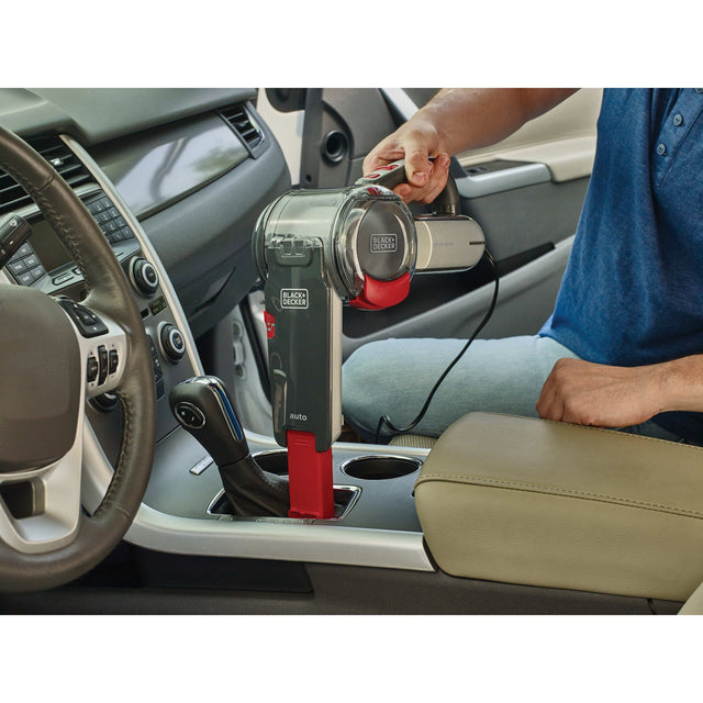 Pivot Vac car handheld vacuum being used to clean gear shift area in car.